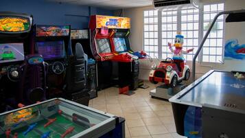 Experience the excitement of gaming in this room, featuring a range of machines and a foosball table.