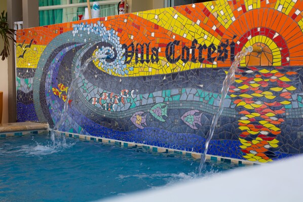 Una piscina con mosaicos de diseño ondulado y el texto "Casa de Correição".