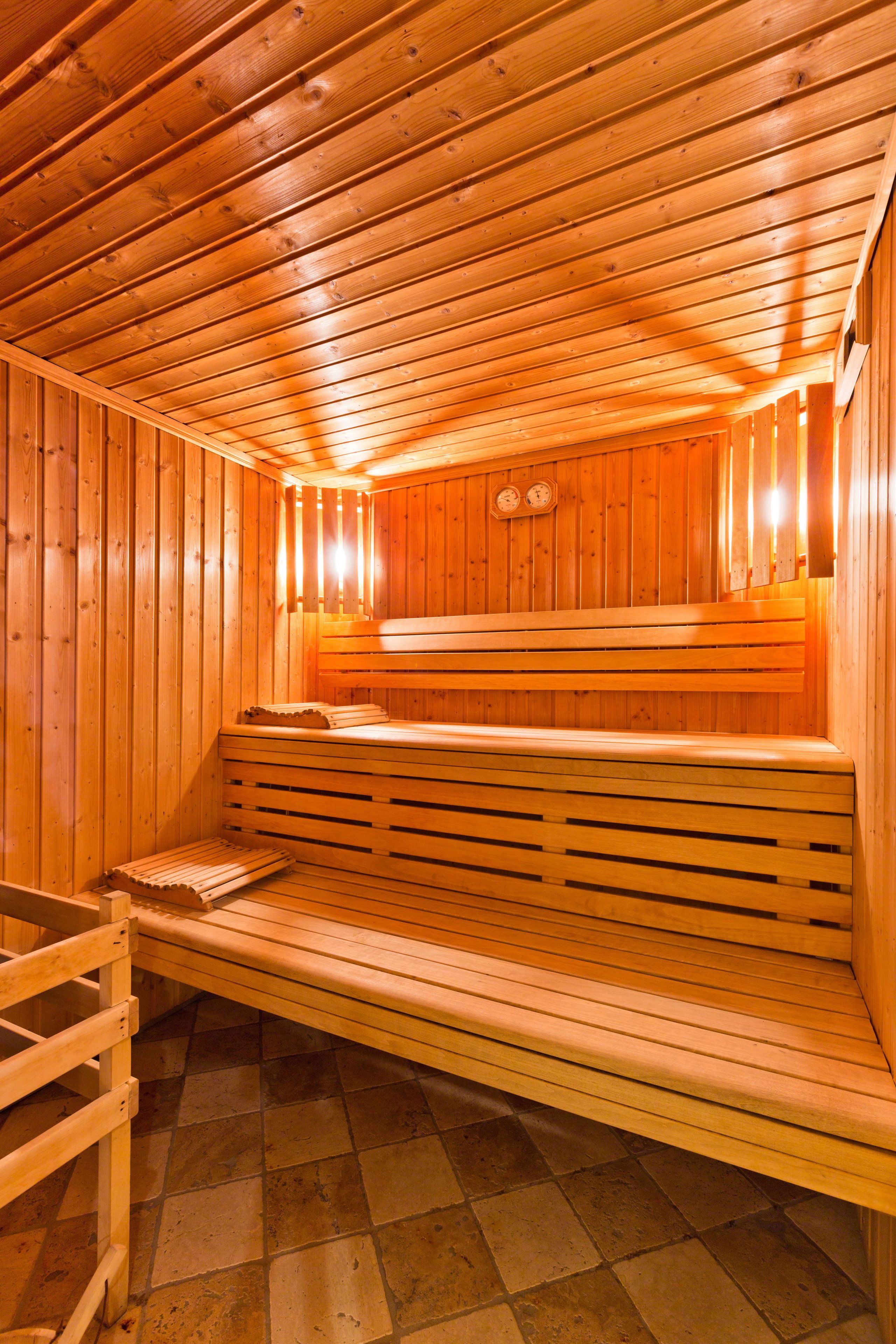 Sauna, jossa on puiset lauteet ja laatoitettu lattia.