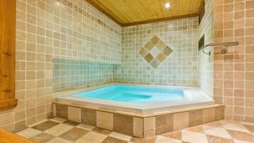 Un jacuzzi en una habitación con paredes de baldosas y techo de madera.