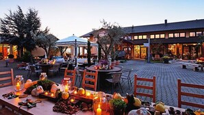 An outdoor dining area with tables set for a meal, surrounded by potted plants and candles. - Burgunderhof Hotel - Adults Only (Hagnau)