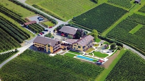 A large estate with multiple buildings, expansive green fields, and a swimming area. - Burgunderhof Hotel - Adults Only (Hagnau)