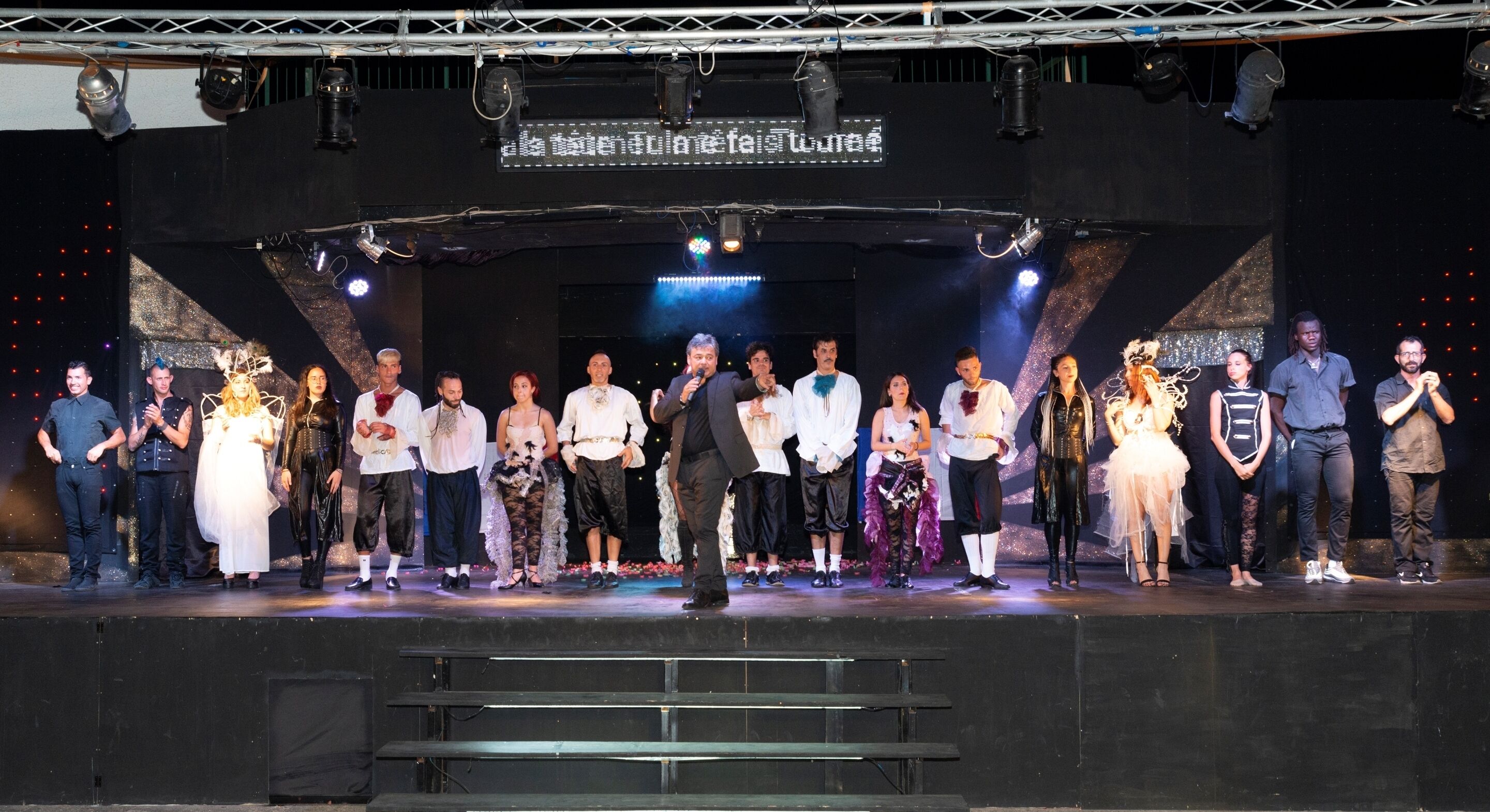A group of people on a stage with a banner above them.