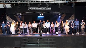 A group of people on a stage with a banner above them.