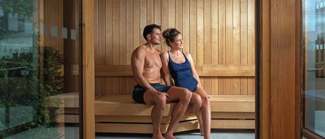 A sauna with wooden benches and a glass wall.