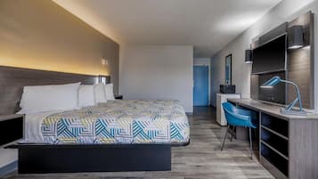 Una habitación de hotel moderna con cama, escritorio y televisión.
