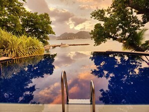 A swimming pool with a view of a body of water and distant mountains. - Cerf Island Resort (Cerf Island)
