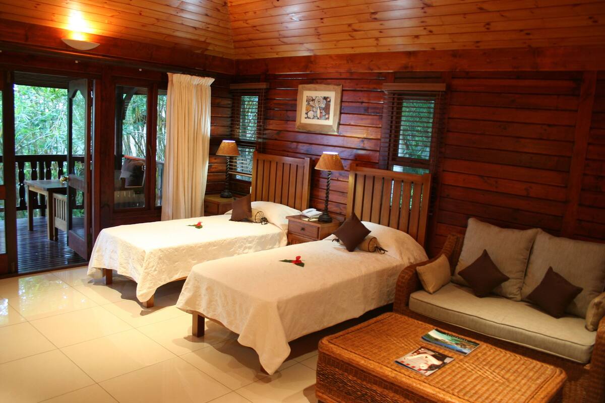 A cabin with two beds, a sofa, and a dining table.