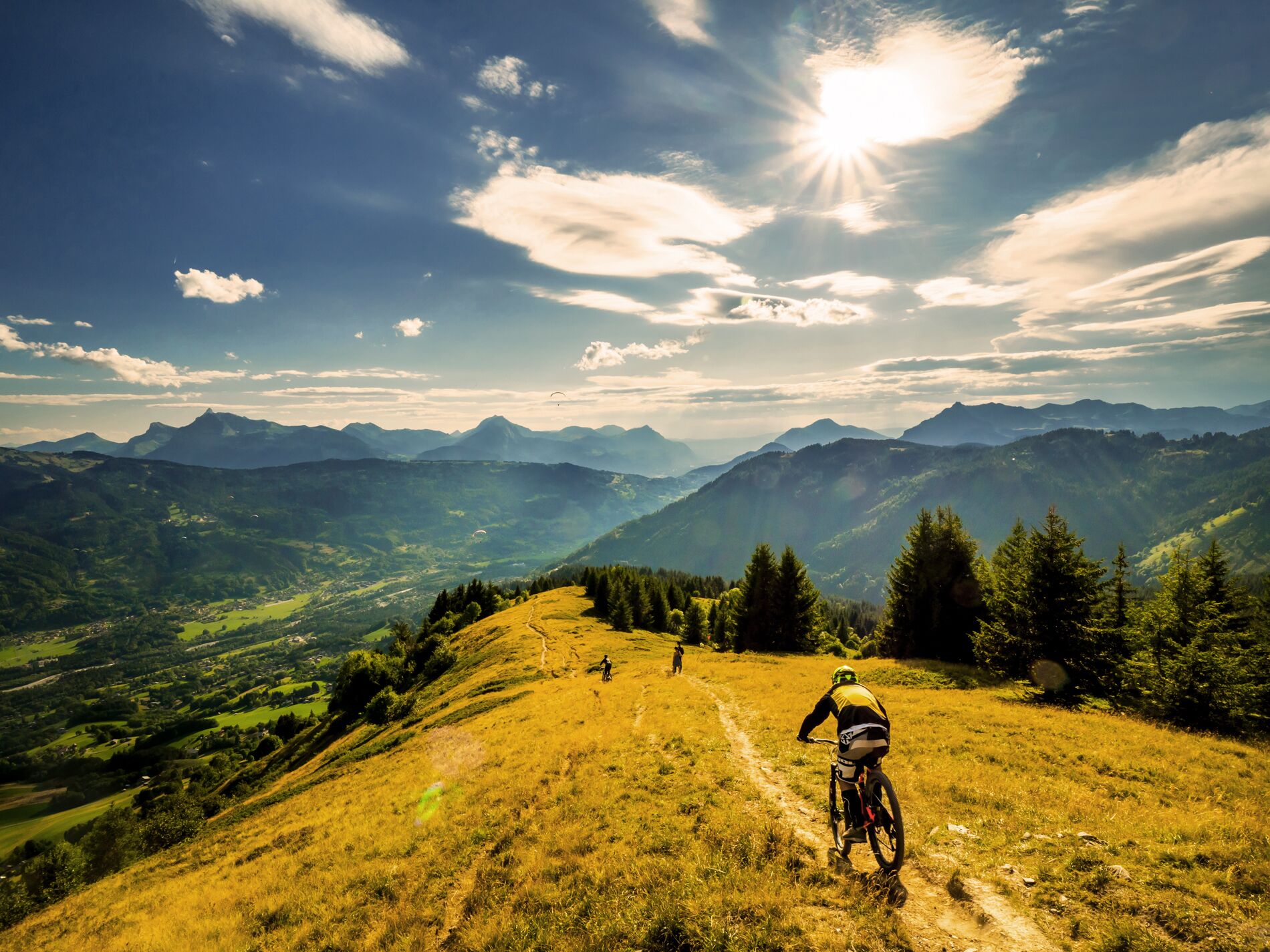 Sendero para bicicletas de montaña con vistas a montañas distantes y un cielo despejado.