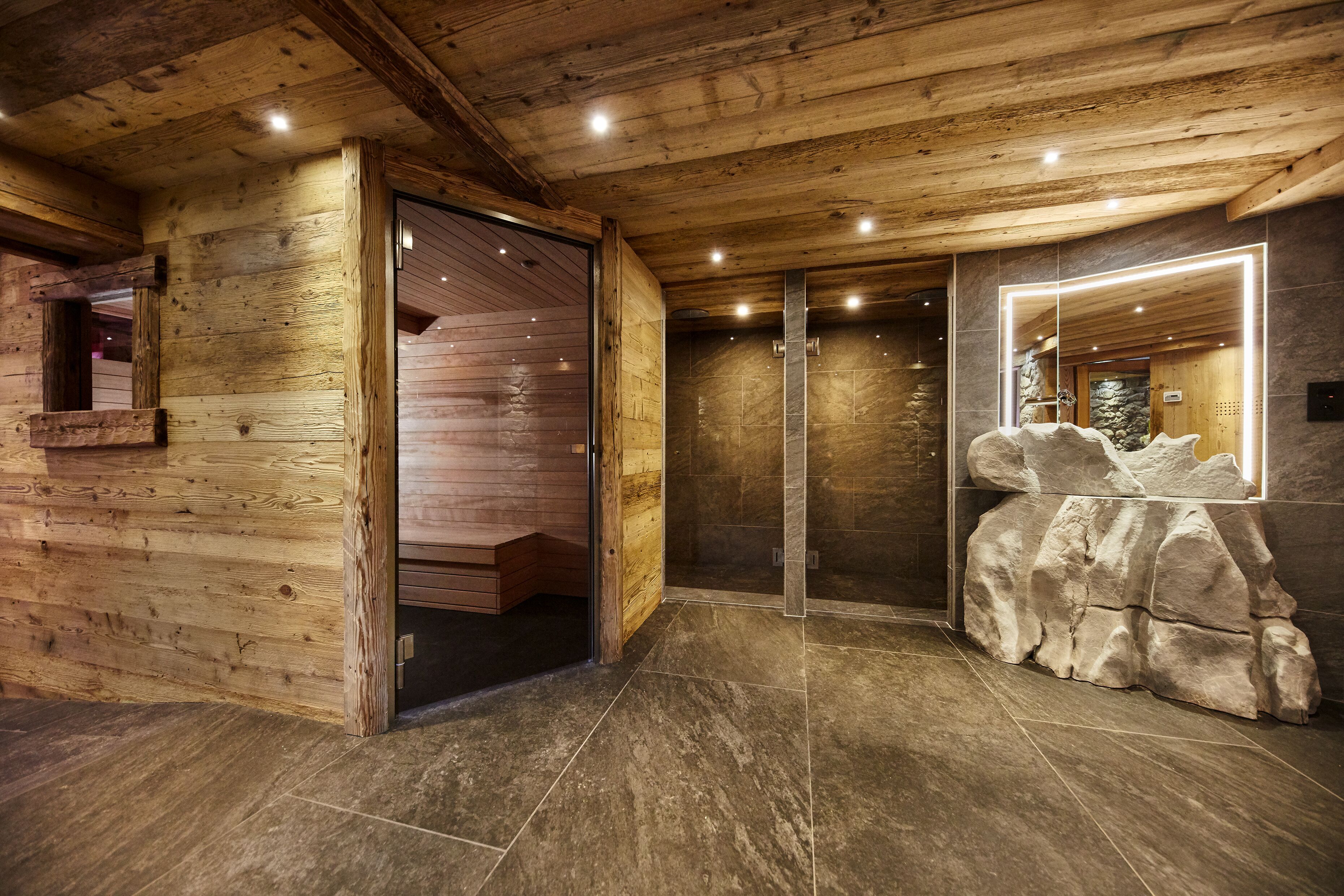 A wooden interior with a stone wall and a large rock feature.