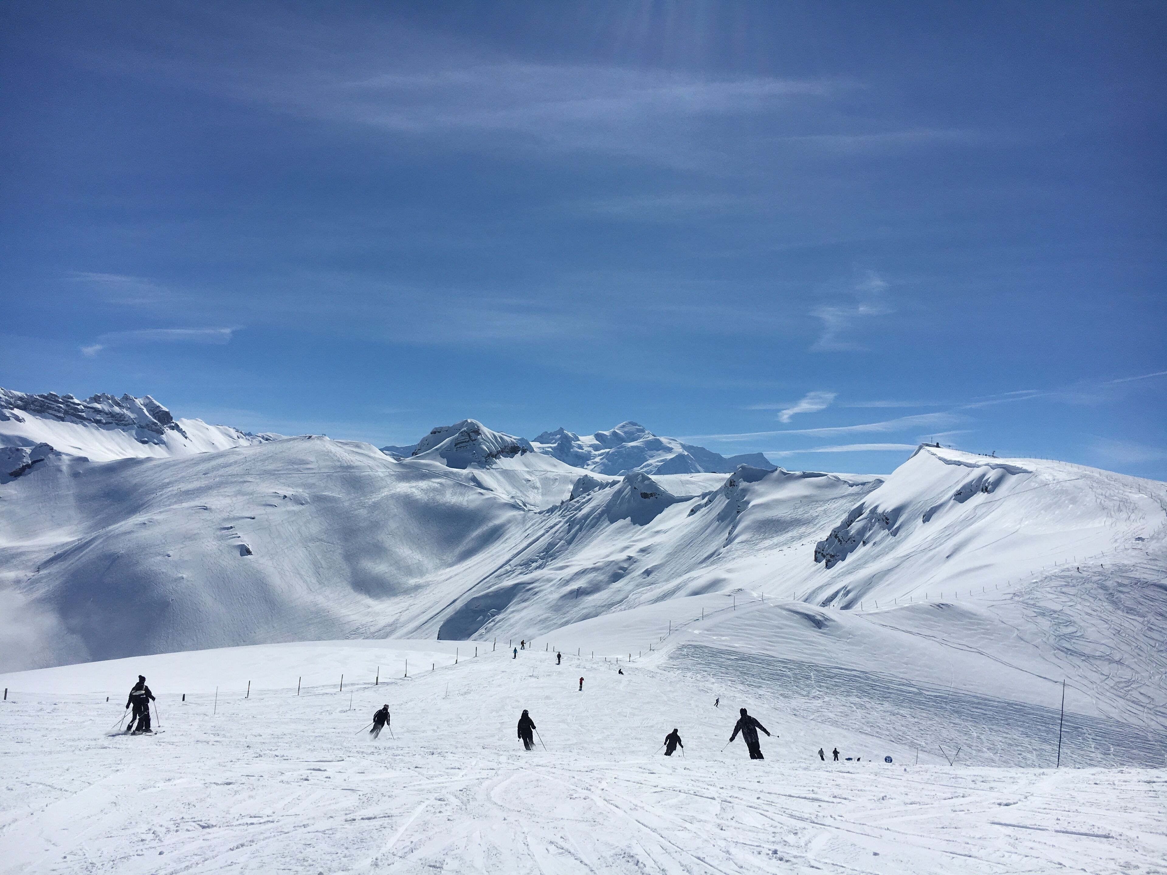 A snowy mountain landscape with skiers.