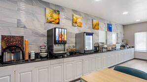 Een moderne keuken met een koffieapparaat, een koelkast en een magnetron.