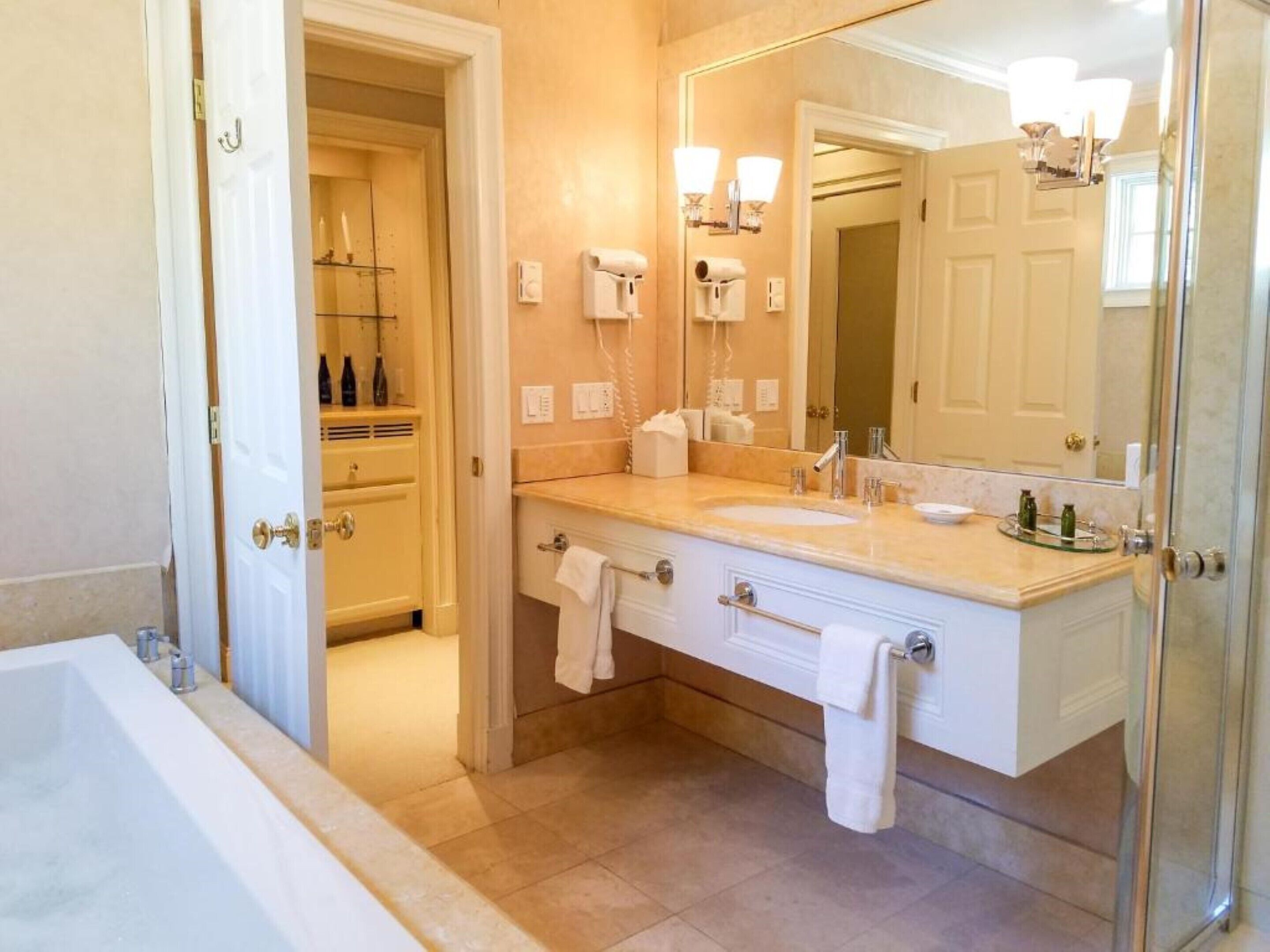 A modern bathroom with a bathtub, a double sink vanity, and a large mirror.