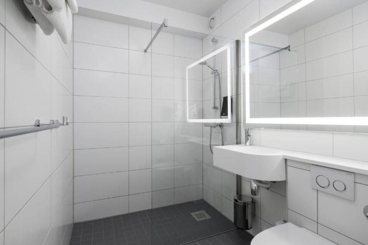 Une salle de bain moderne équipée d’une douche, d’un lavabo et de toilettes.