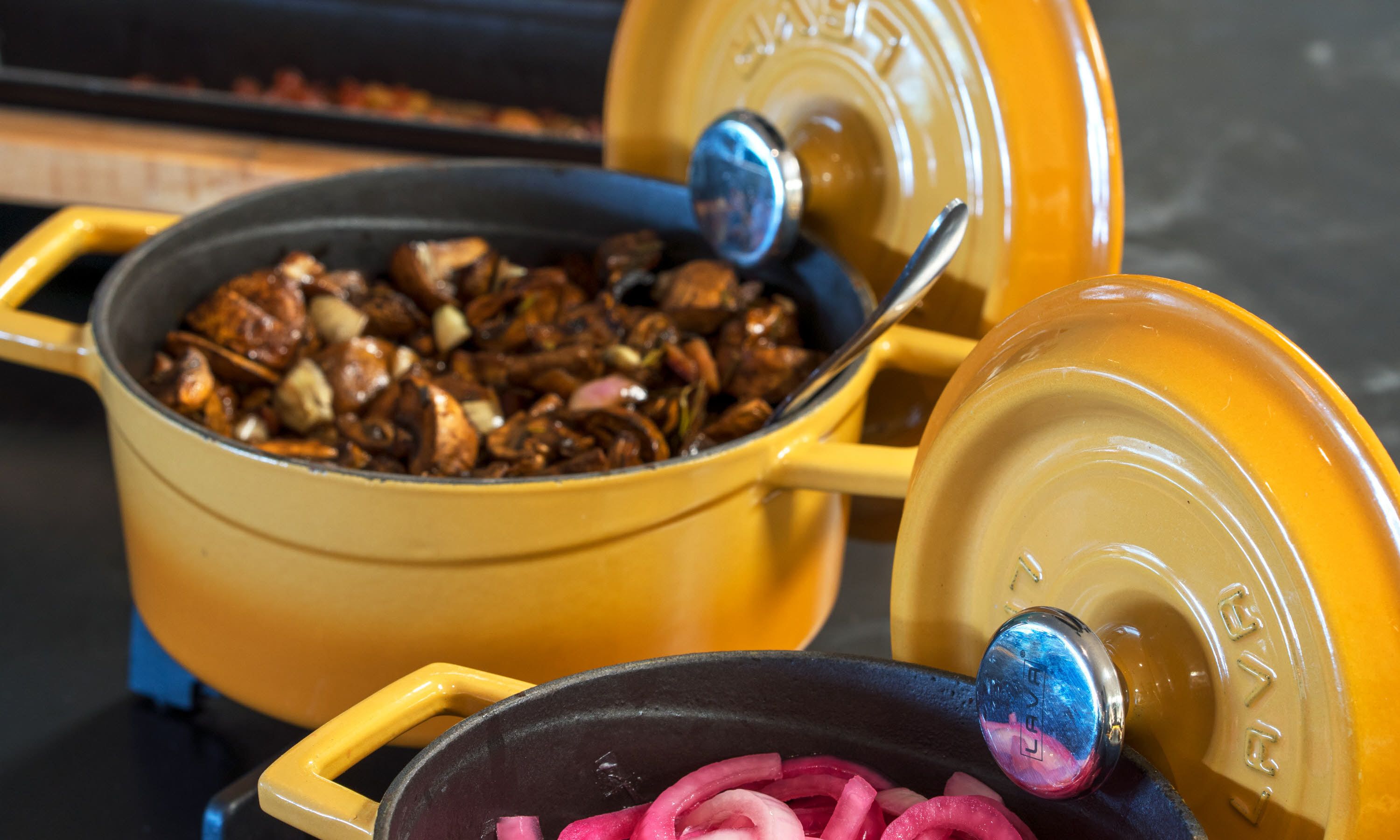 Une casserole jaune avec un couvercle, posée sur une cuisinière.