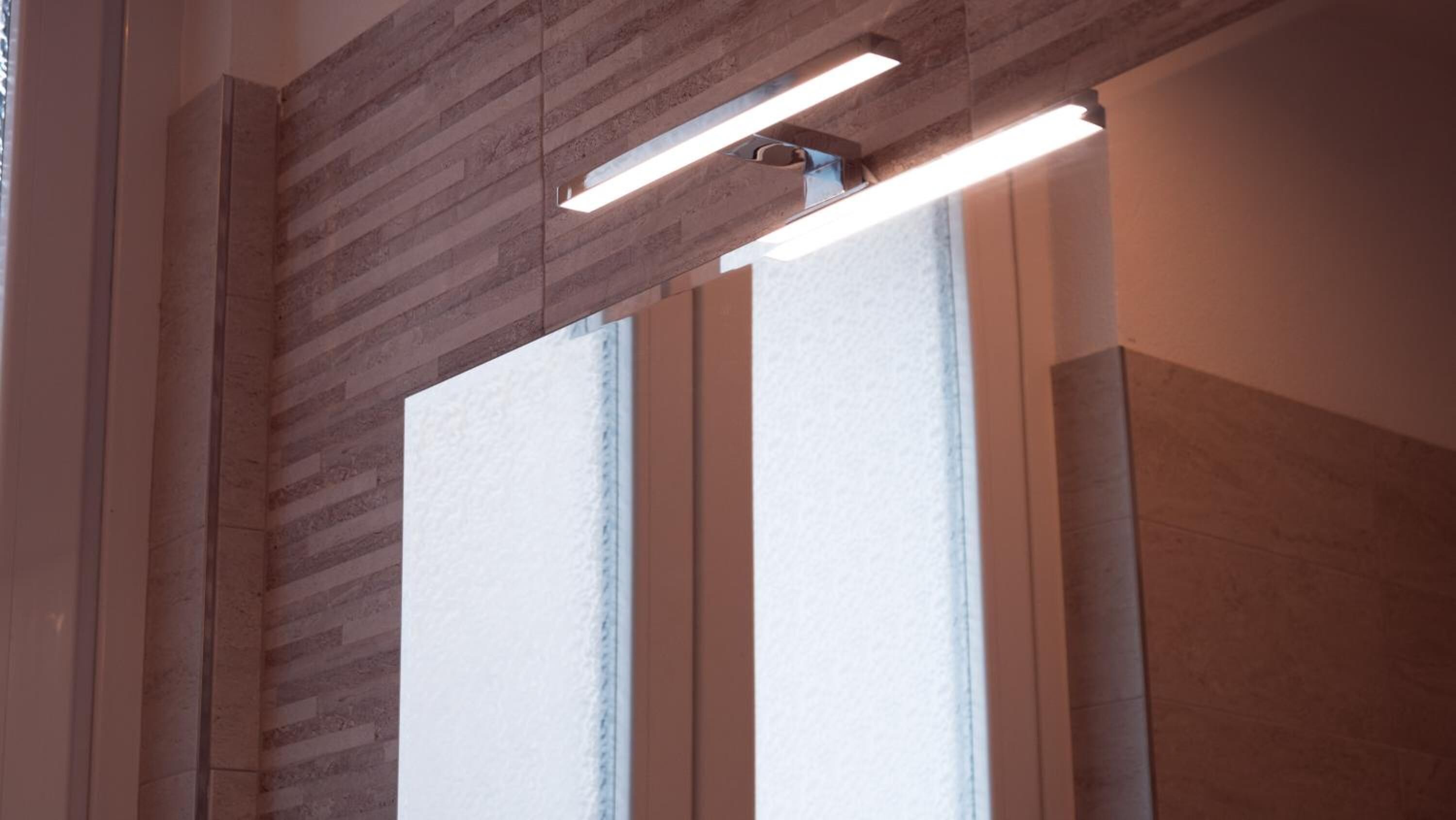 Un intérieur moderne avec un mur lambrissé et une grande fenêtre équipée de stores.