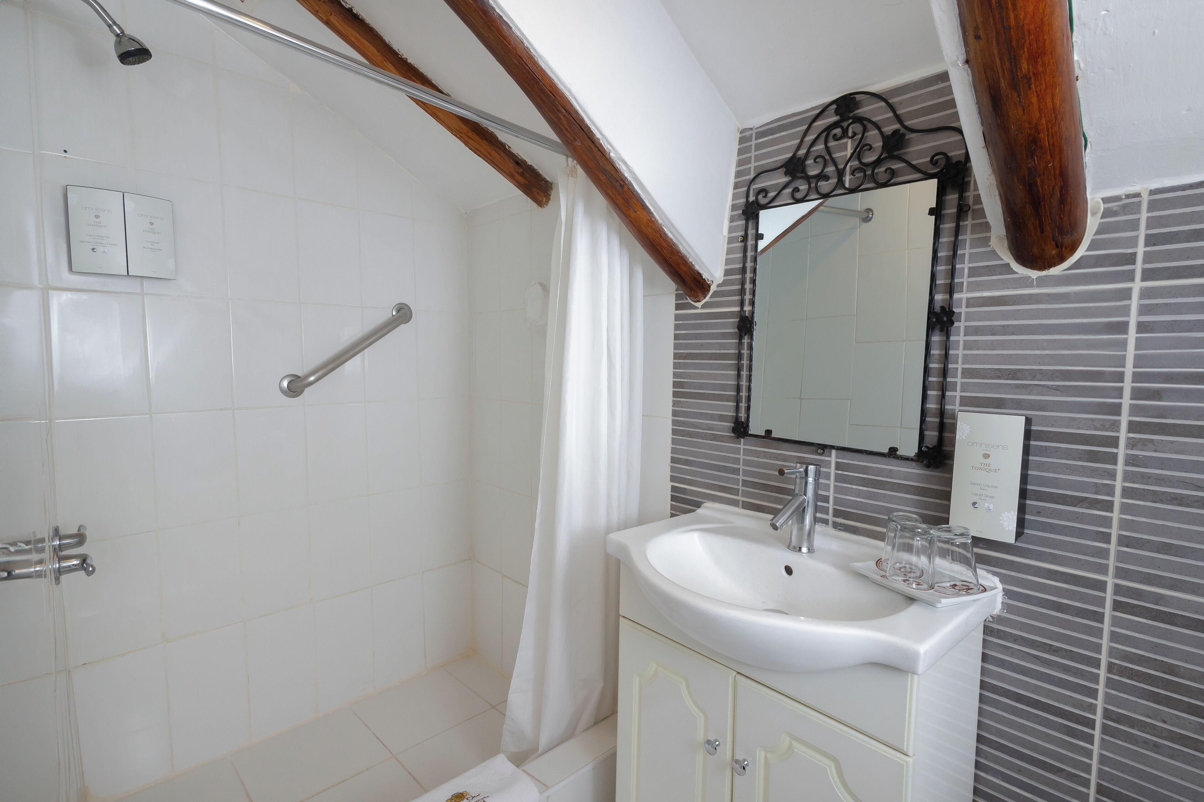 A bathroom with a shower, a sink, and a mirror.