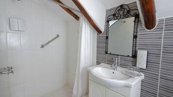 A bathroom with a shower, a sink, and a mirror.