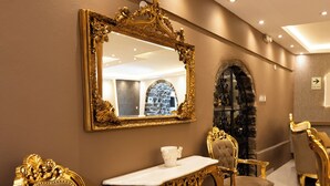 A luxurious dining area with ornate gold furniture, a marble table, and a large mirror on the wall. - Hotel Hacienda Cusco Plaza (Cusco)