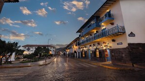 A cobblestone street lined with buildings featuring balconies and outdoor lighting. - Hotel Hacienda Cusco Plaza (Cusco)