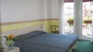 Camera da letto con un letto, un comodino, una sedia e vista all'esterno tramite una porta.