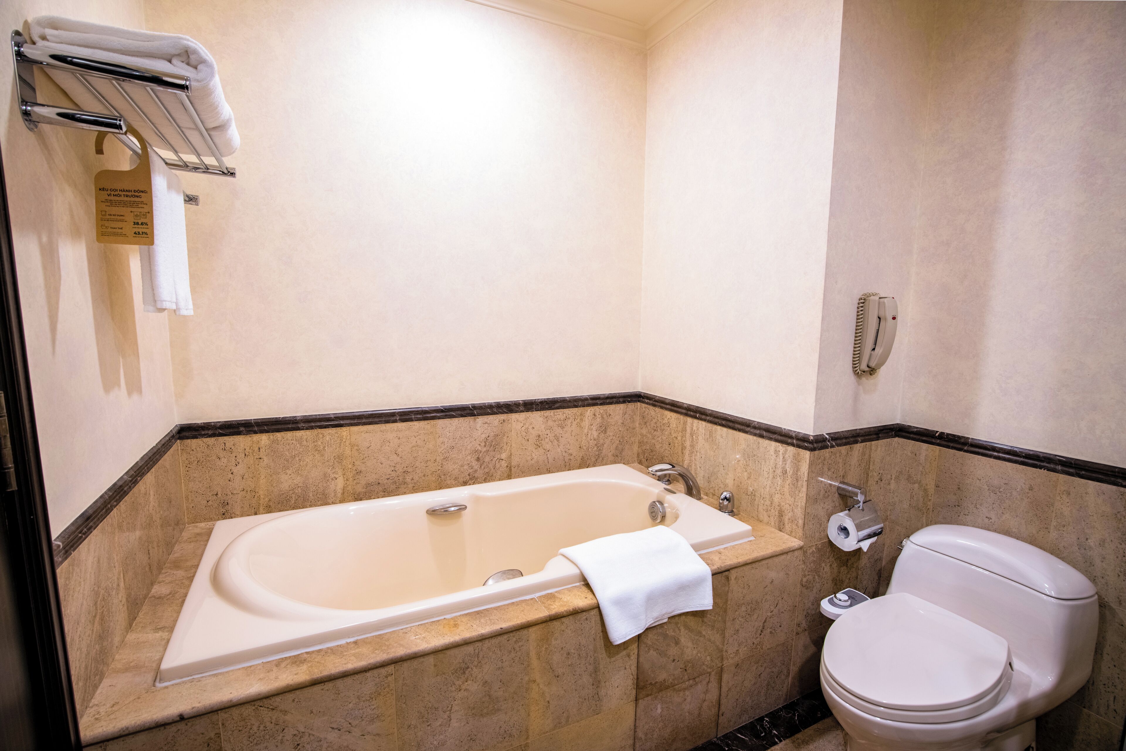 Une salle de bain avec une baignoire, des toilettes et un porte-serviettes.