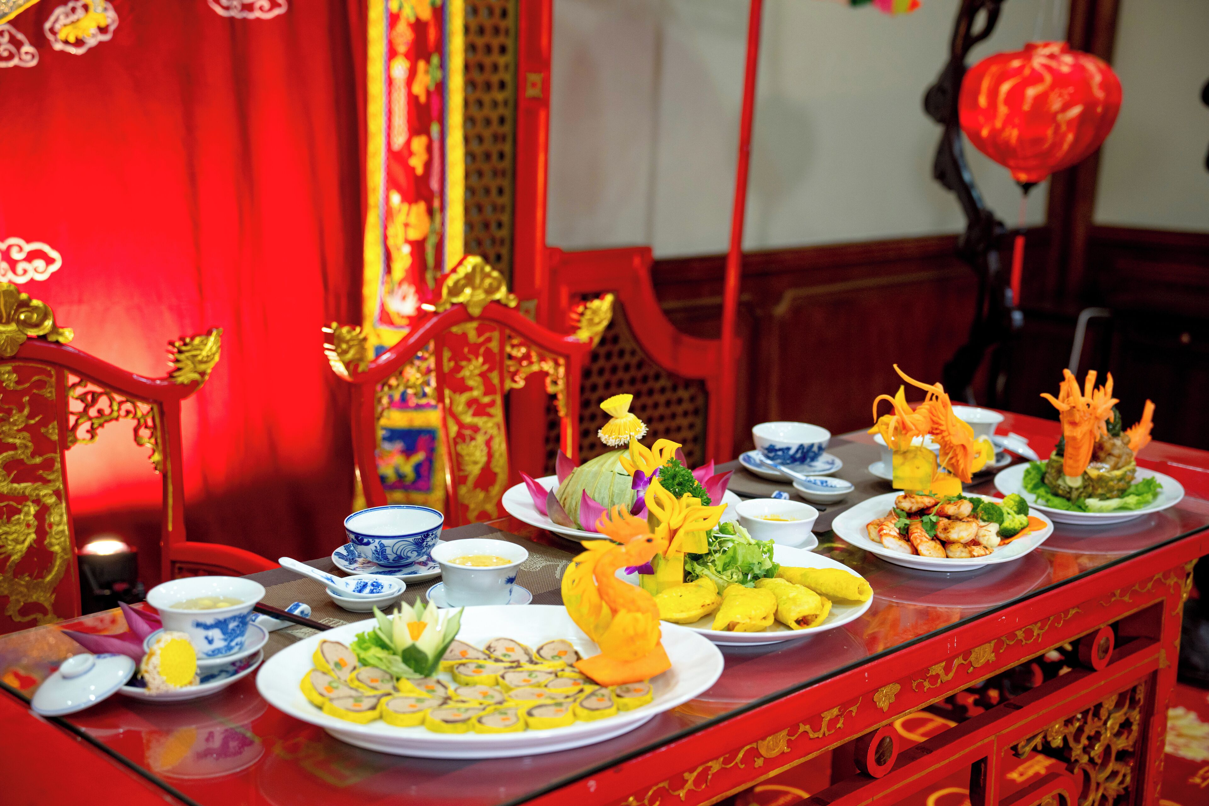 A table set with various dishes and traditional decorations, indicating a festive or cultural event.