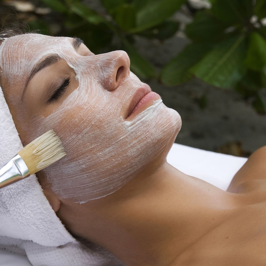 A person receiving a facial treatment with a brush.