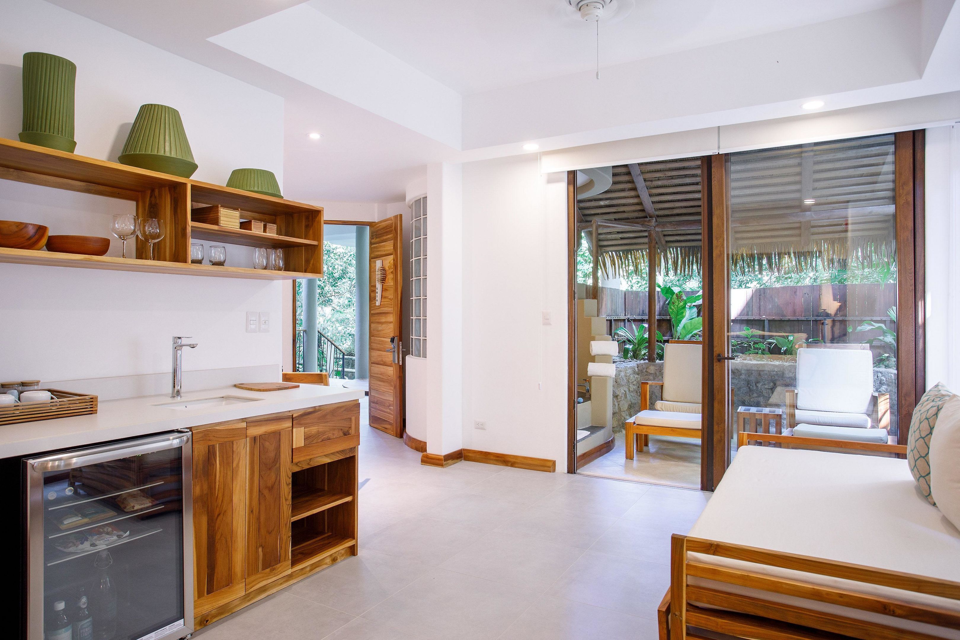 Una cocina moderna con armarios de madera, lavavajillas integrado y un amplio ventanal con vistas a un patio.