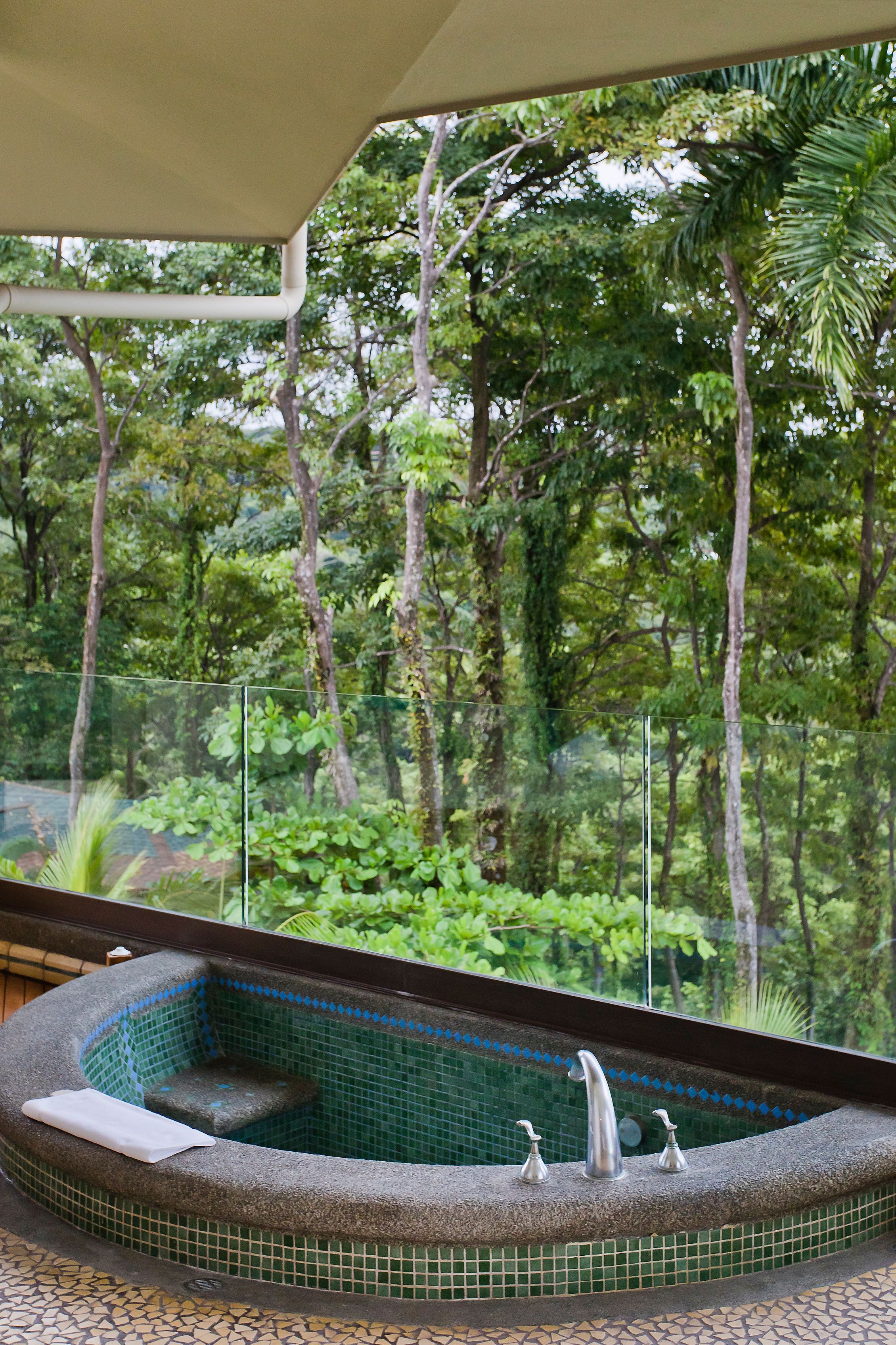 A hot tub with a view of a lush, green forest.