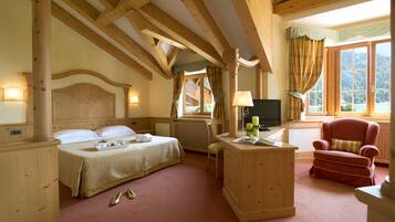 A hotel room with two beds, a wooden desk, a red armchair, and a TV.