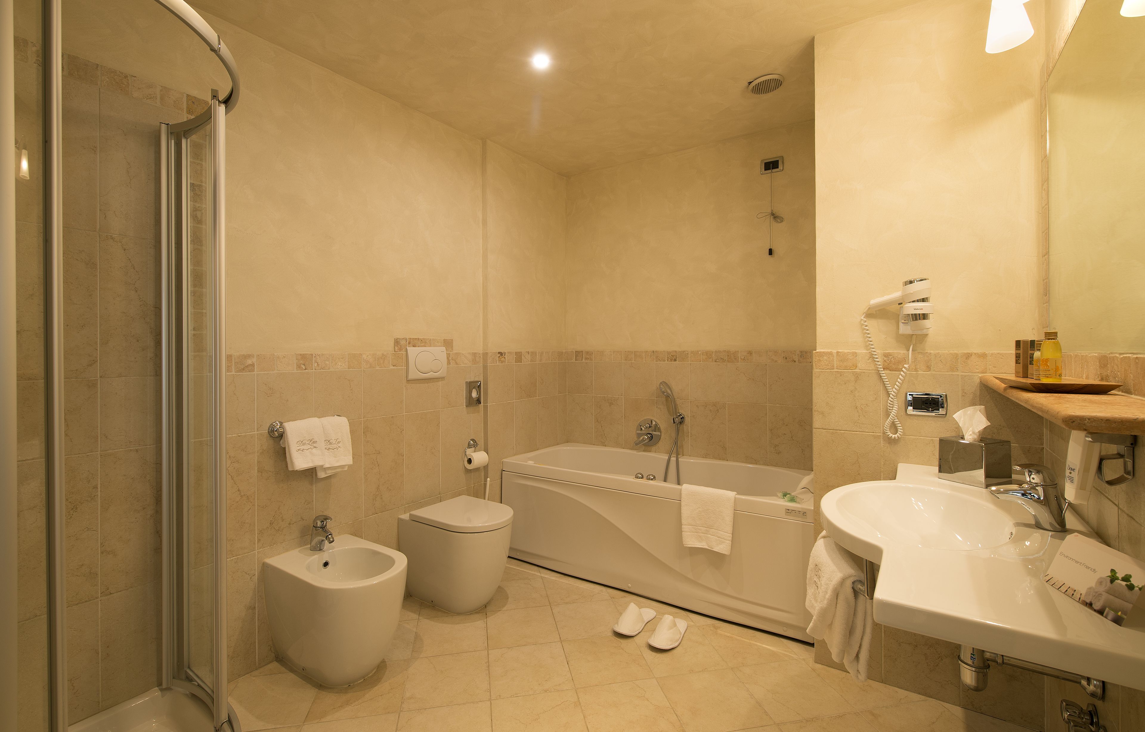 Een moderne badkamer met douche, toilet, bad en wastafel.