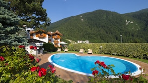 Un hôtel doté d’une piscine, entouré d’une végétation luxuriante et de montagnes.