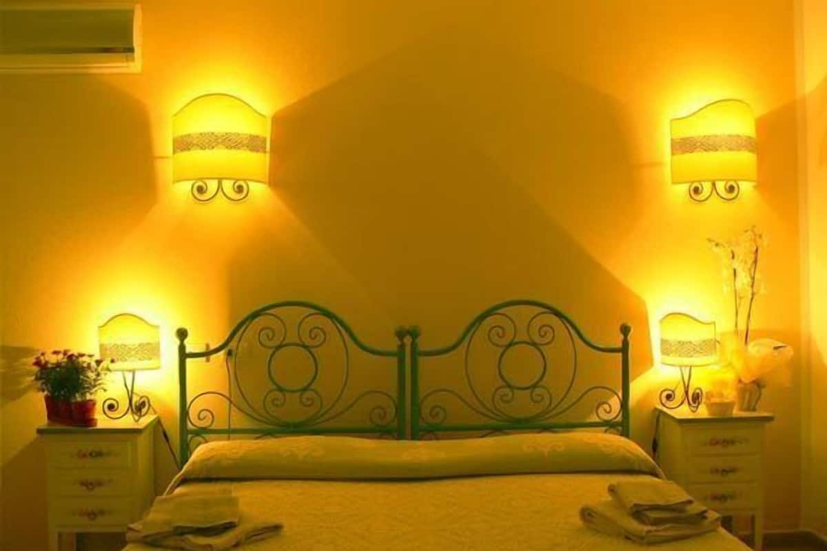 Ein Schlafzimmer mit einem Bett, zwei Nachttischen und Wandleuchten.