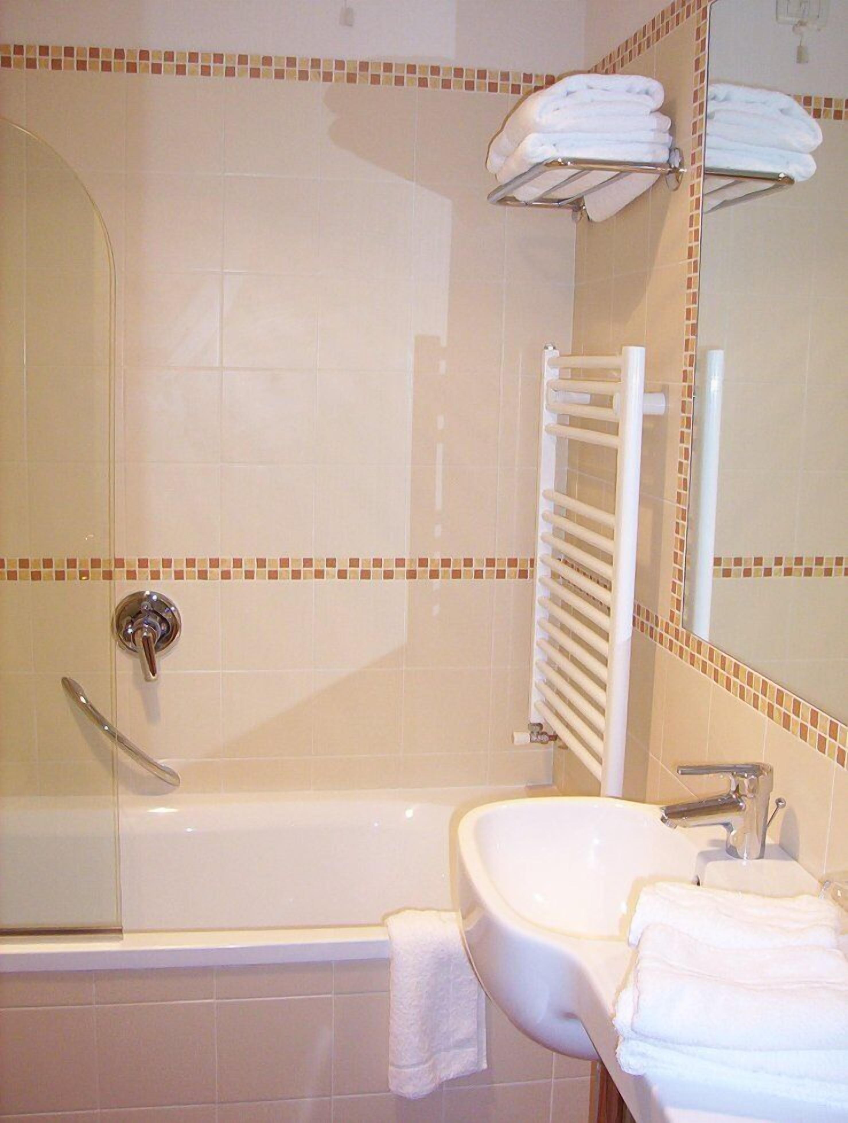 Un baño con bañera, lavamanos, ducha y espejo.