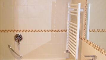 Une salle de bain avec une baignoire, un lavabo, une douche et un miroir.
