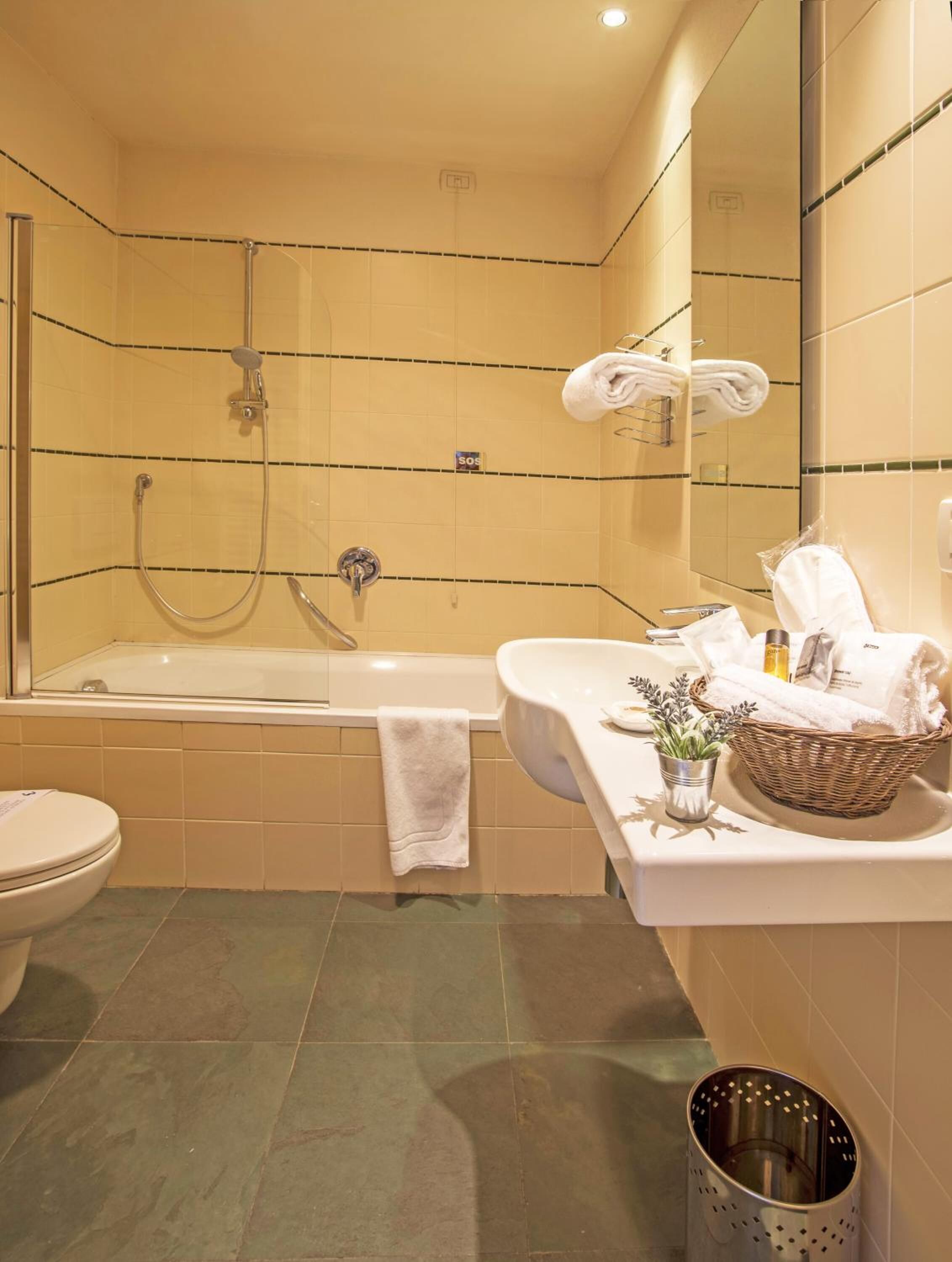 A bathroom with a bathtub, a shower, a toilet, and a sink.