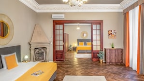 A hotel room with a bed, a fireplace, a chandelier, and a view of the hallway. - Hotel Palác U Kočků by Adrez Living (Prague)