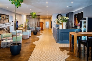 A hotel lobby with seating areas, a reception desk, and a large clock. -  Hotel Chateau Kurfürstendamm (Berlin)