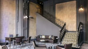 Un hall d’entrée spacieux, doté d’un escalier moderne, de sièges en cuir et d’une atmosphère bien éclairée.