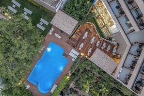 Una piscina al aire libre de temporada, sombrillas