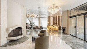 A spacious lobby with a fireplace, seating area, and a reception desk. - Civitel Akali Hotel (Chania)
