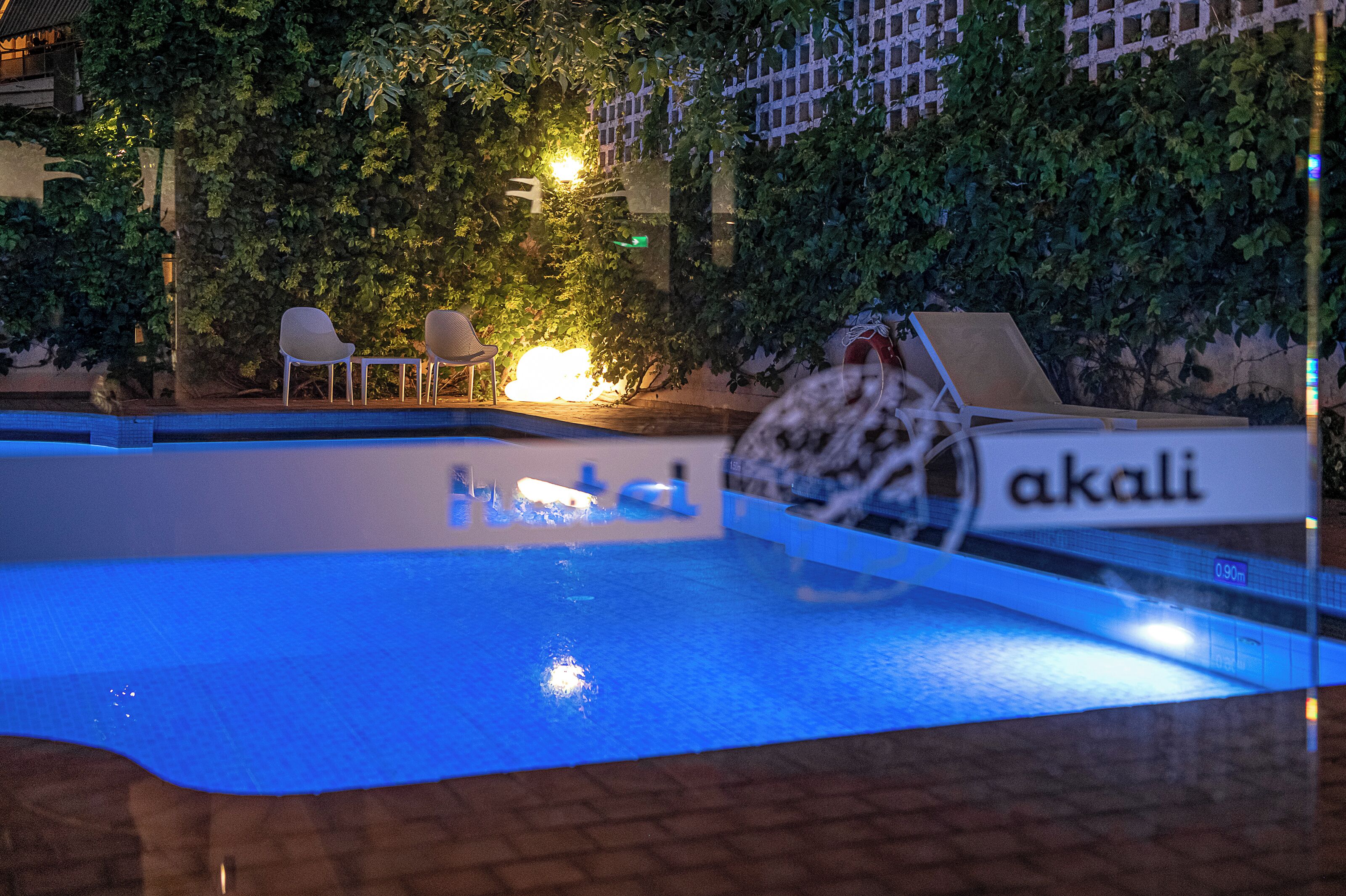 A swimming pool with lounge chairs and a sign that reads "akali".