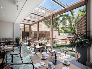 Enjoy meals in this open-plan dining area with comfortable seating and large windows offering views of the surrounding greenery.