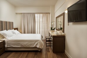 Relax in a cozy space with a made bed, flat-screen TV, and a coffee maker.