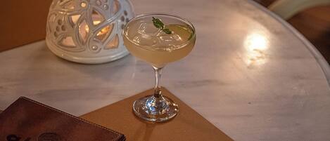 A table with a martini glass, a menu, and a decorative lantern.