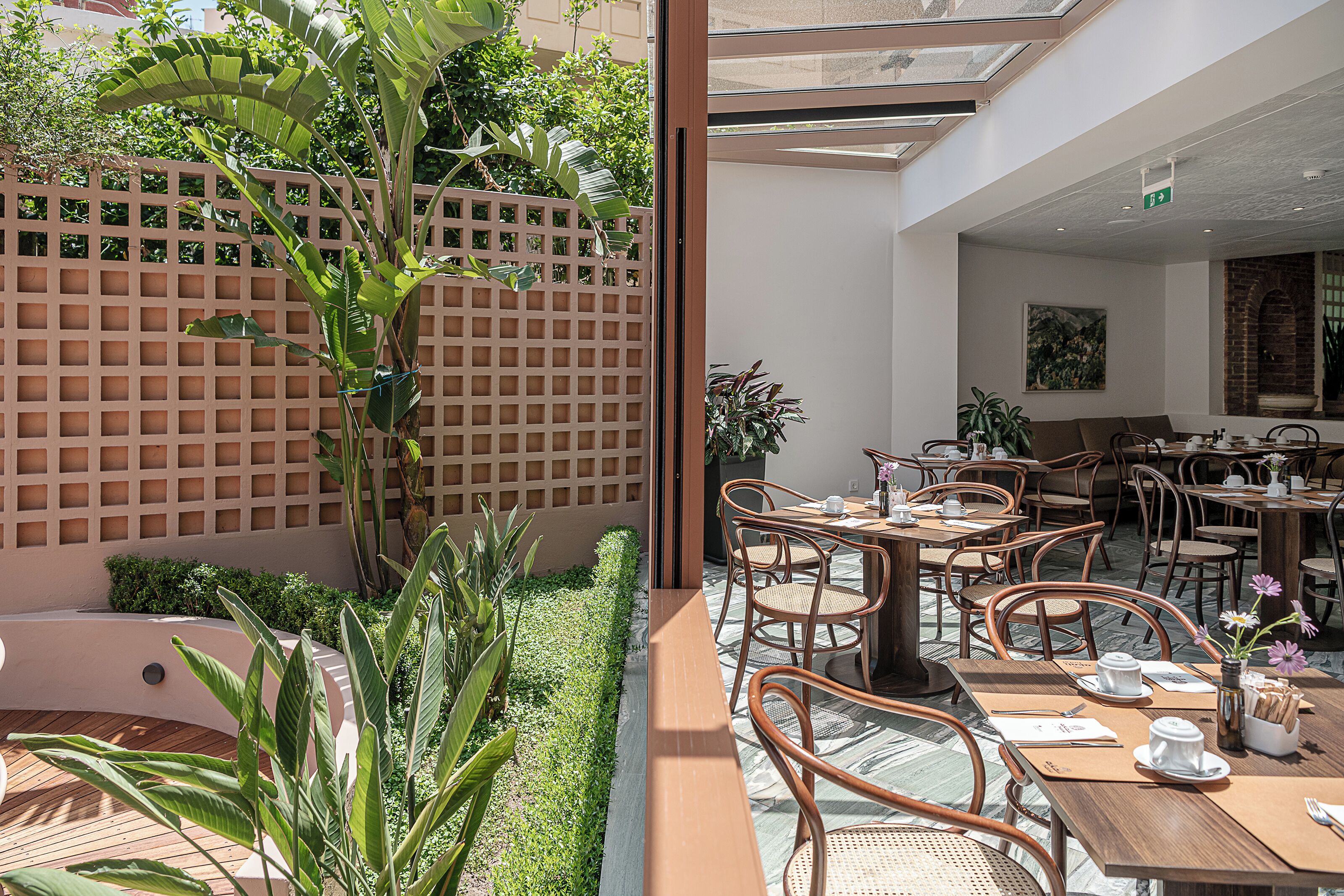 A restaurant with outdoor seating, a brick wall, and a wooden deck.