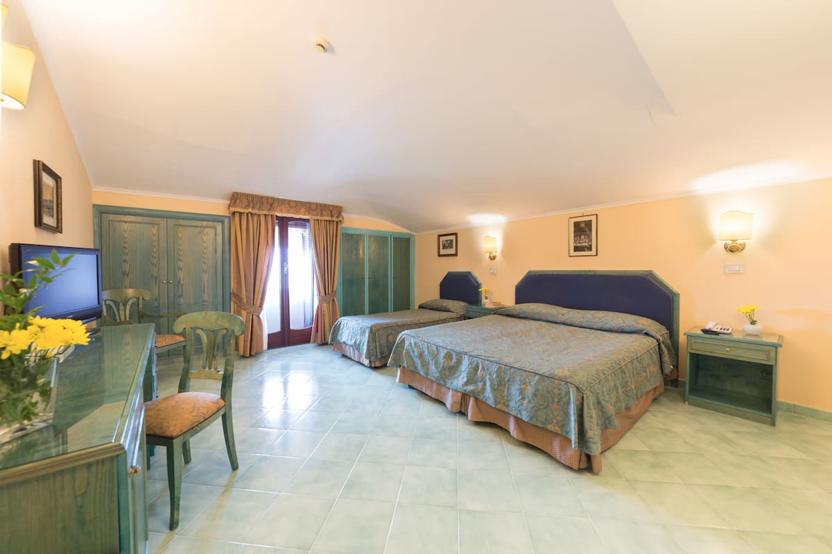 Une chambre avec deux lits, un bureau avec une chaise et un téléviseur.
