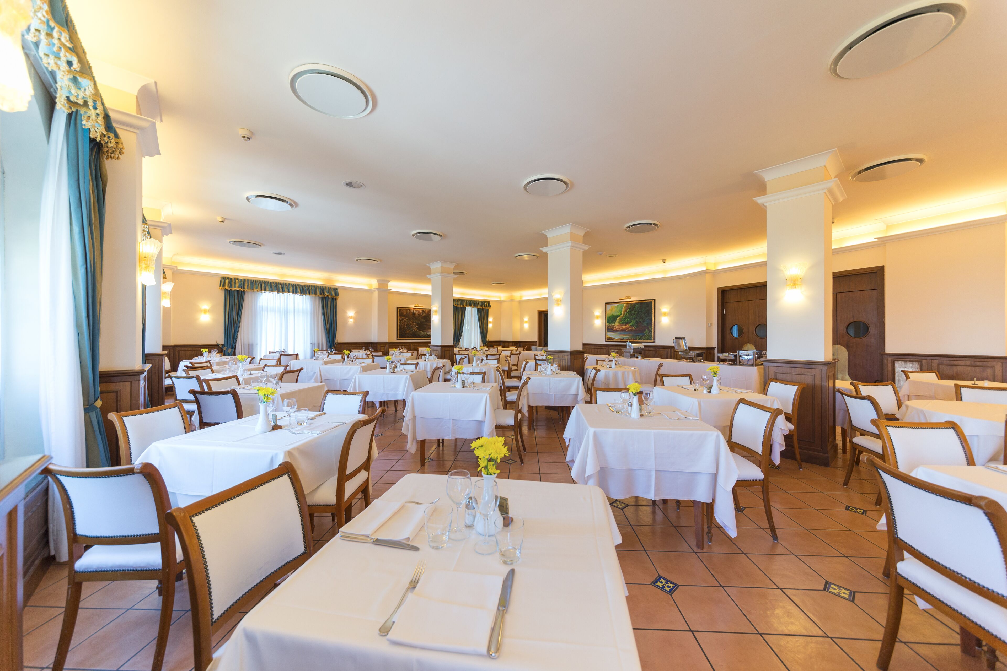 Un amplio comedor con varias mesas y sillas dispuestas al estilo banquete.