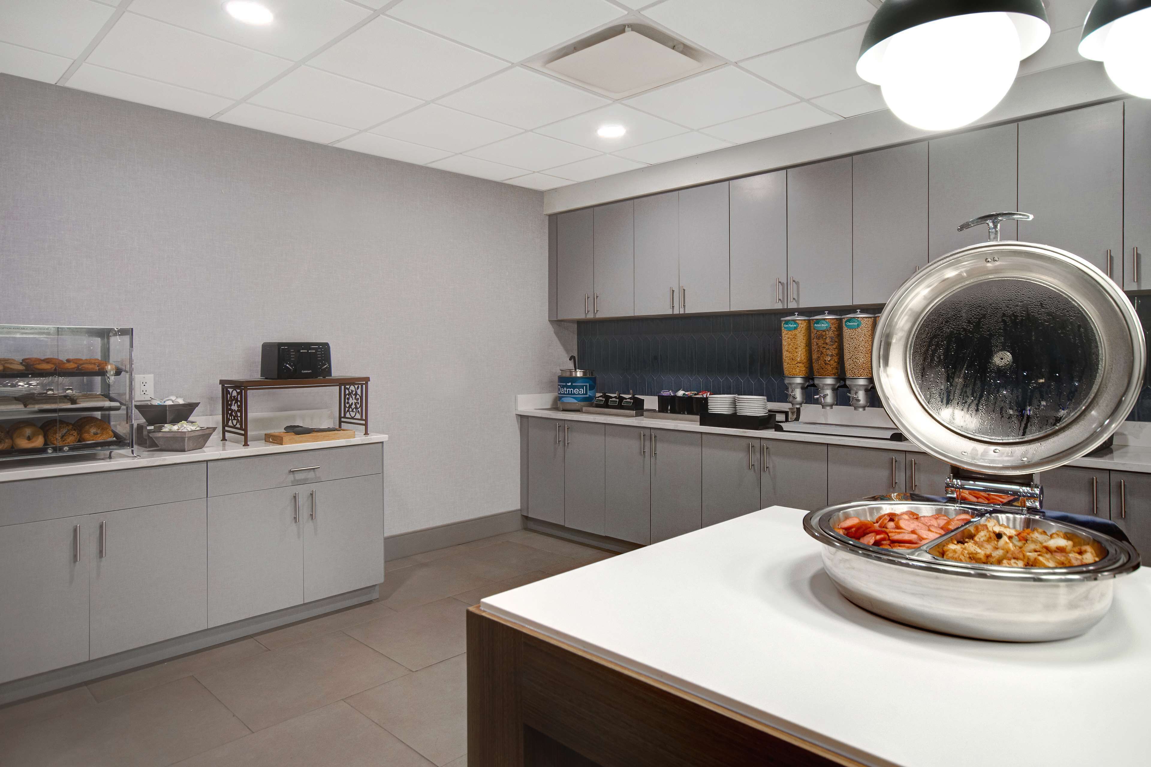 Una cucina moderna con un'area buffet, che include una grande ciotola di cibo e una macchina per il caffè.